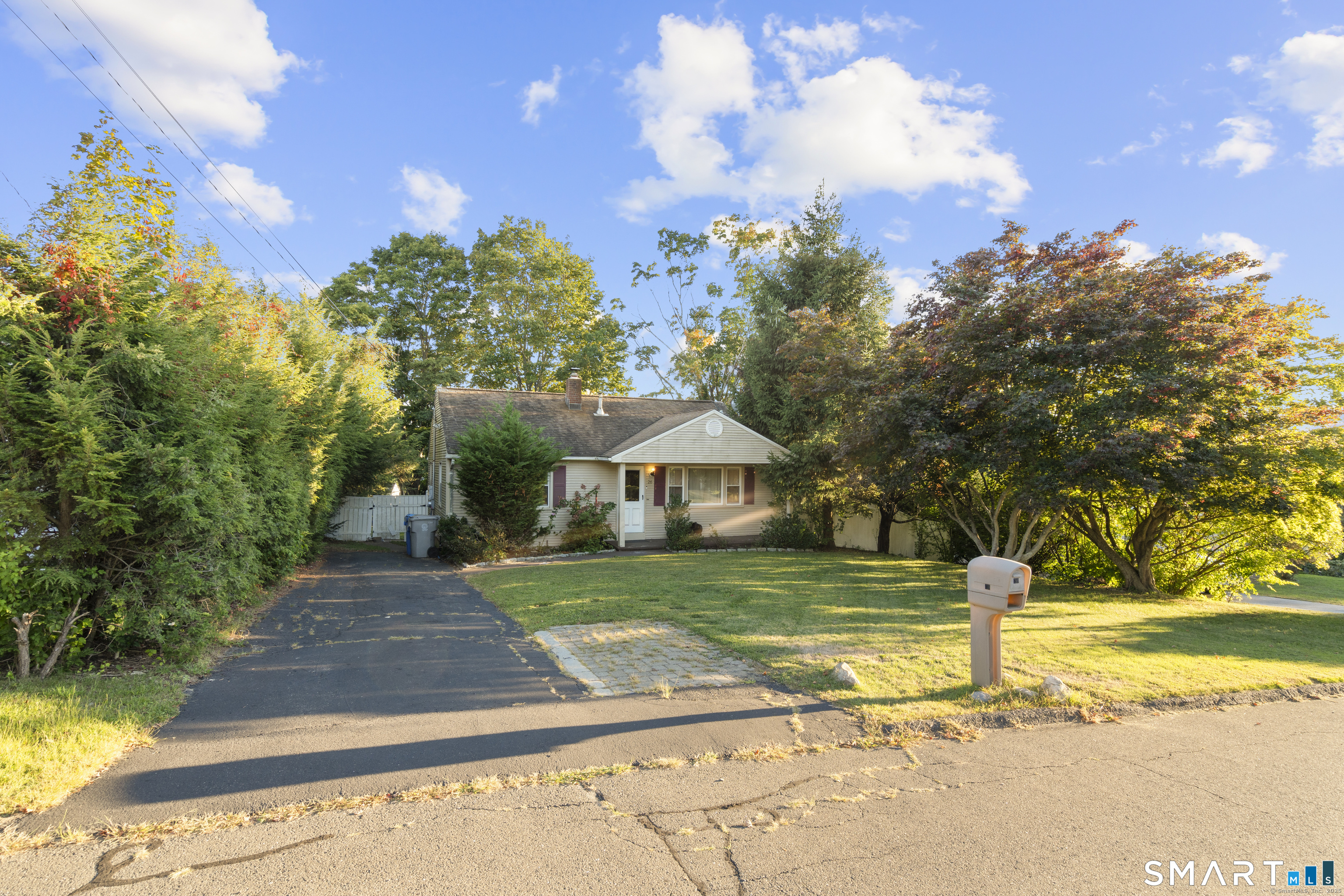 a front view of a house with a yard and trees
