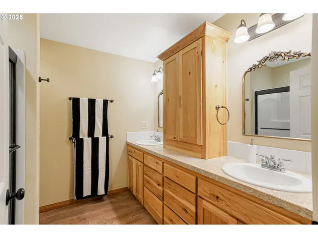 a bathroom with a granite countertop sink mirror and a shower