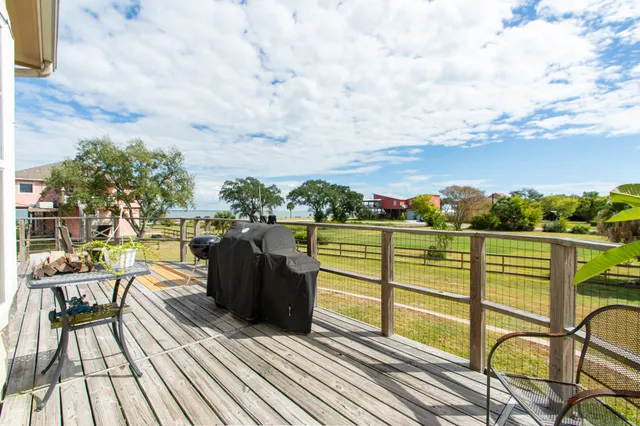 a view of a balcony with wooden floor and iron fence