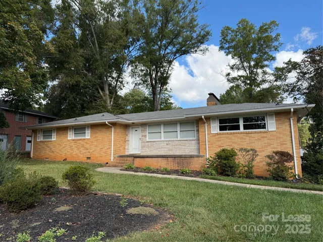 a front view of house with yard and trees around