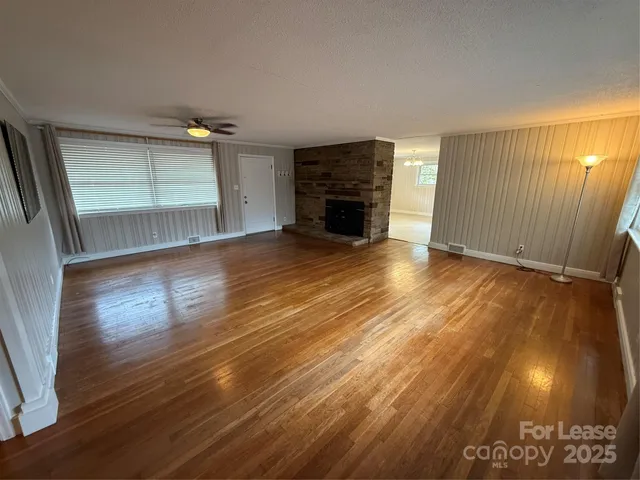 an empty room with wooden floor and fireplace