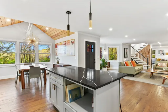 a kitchen with stainless steel appliances granite countertop a sink a stove and chairs