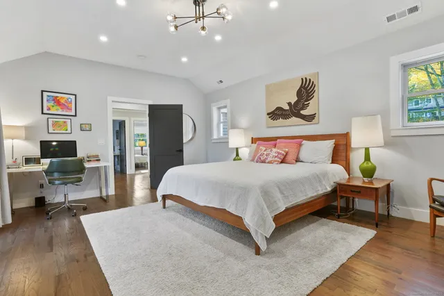a bedroom with a bed and wooden floor