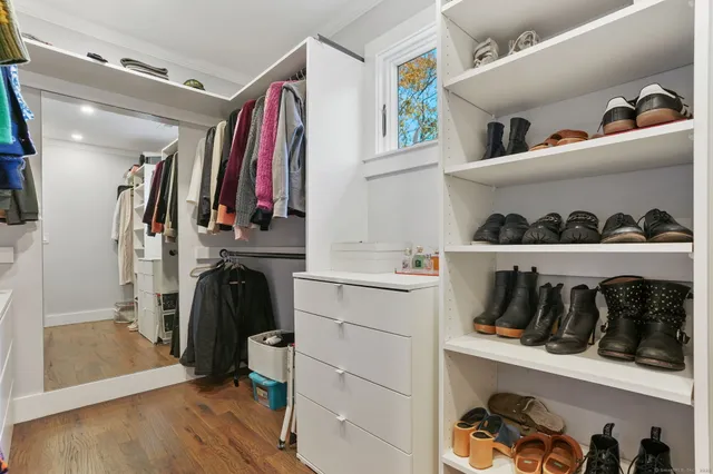 a view of walk in closet with clothes and shoes