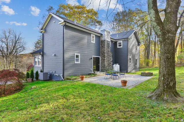 a view of a house with backyard and a tree