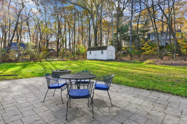 a backyard of a house with table and chairs