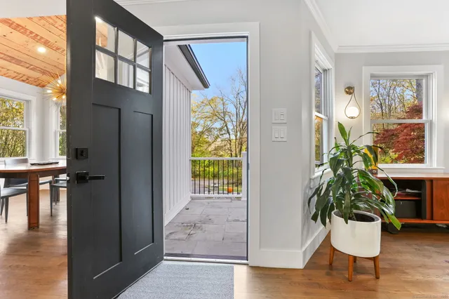 a hallway with wooden floor and a potted plant