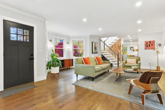 a living room with furniture and a wooden floor
