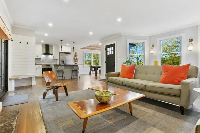 a living room with furniture kitchen view and a window