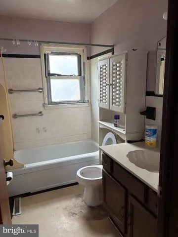 a bathroom with a granite countertop toilet a sink and a bathtub