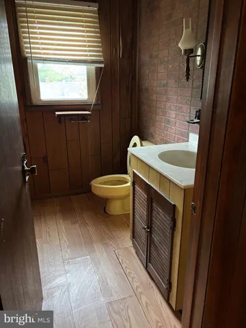 a bathroom with a sink a toilet a window and vanity