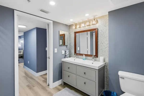 a bathroom with a sink vanity mirror and toilet
