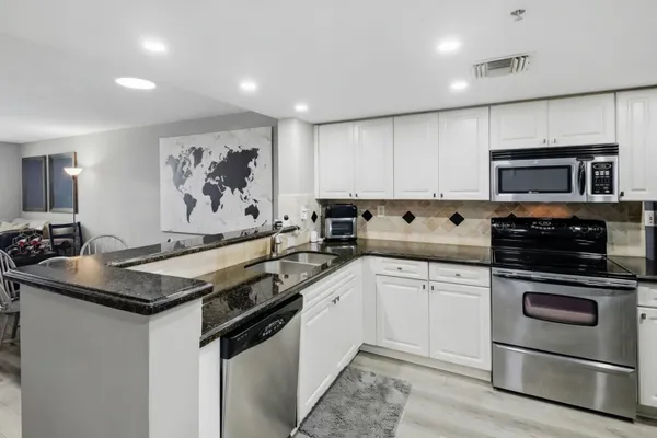 a kitchen with stainless steel appliances a sink stove and microwave