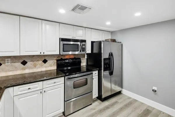 a room with furniture a flat screen tv and a refrigerator