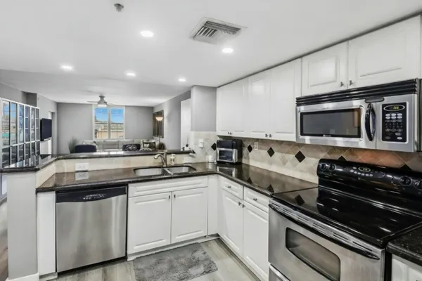a kitchen with stainless steel appliances granite countertop a sink a stove and cabinets