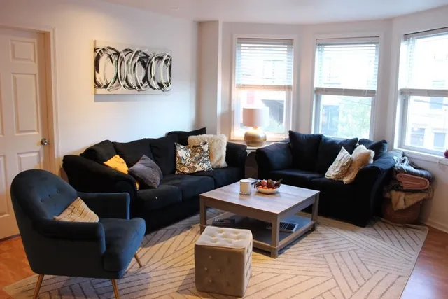 a living room with furniture and a window with wooden floor
