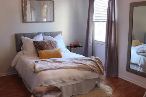 a bed sitting in a bedroom next to a window