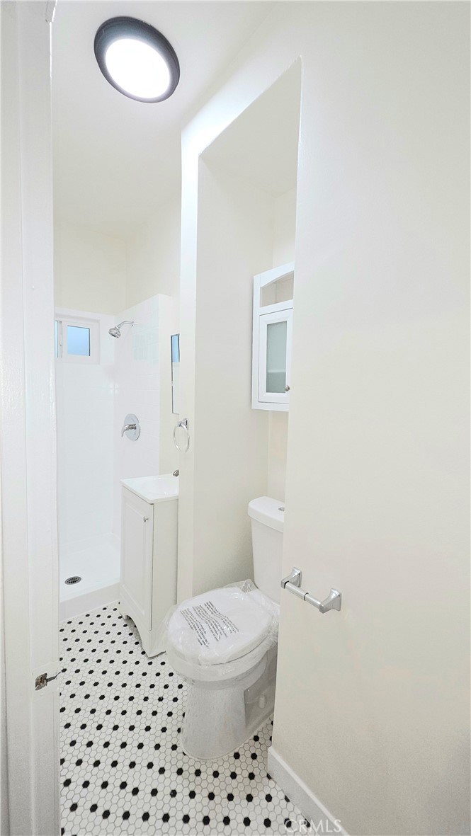 3408 Sunset Boulevard, Unit 107 Silver Lake, CA 90026 - Photo 11 of 12 a bathroom with a sink a toilet a shower and a mirror