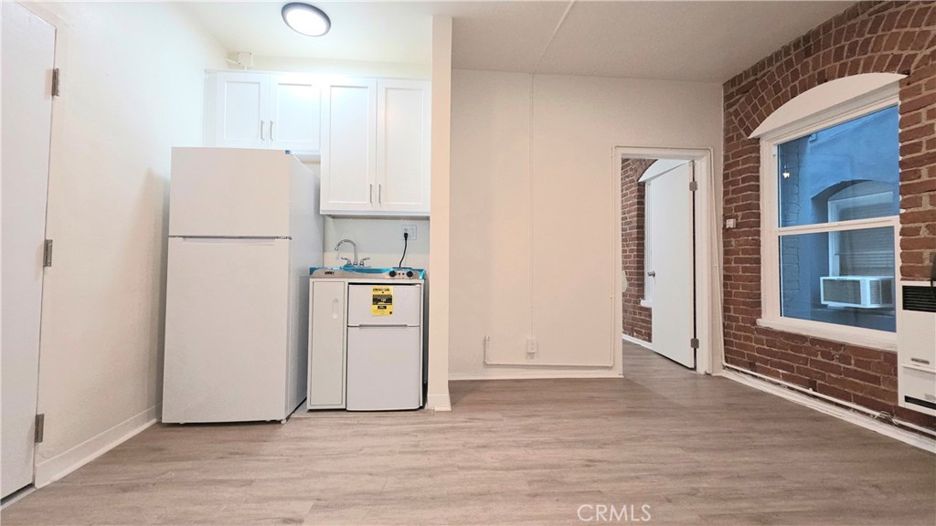 3408 Sunset Boulevard, Unit 107 Silver Lake, CA 90026 - Photo 3 of 12 a view of a kitchen with refrigerator and wooden floor