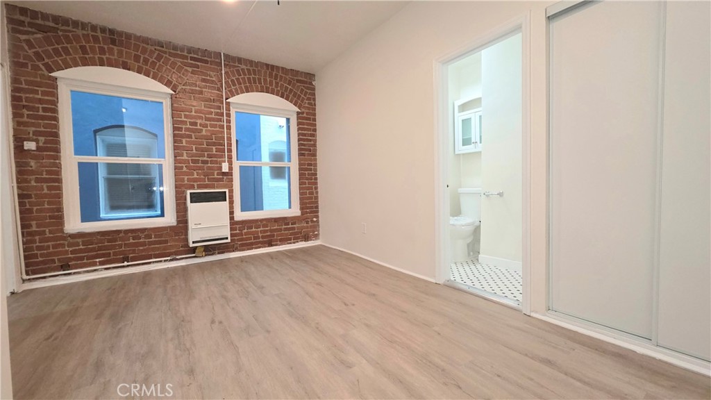 3408 Sunset Boulevard, Unit 107 Silver Lake, CA 90026 - Photo 4 of 12 an empty room with wooden floor and windows