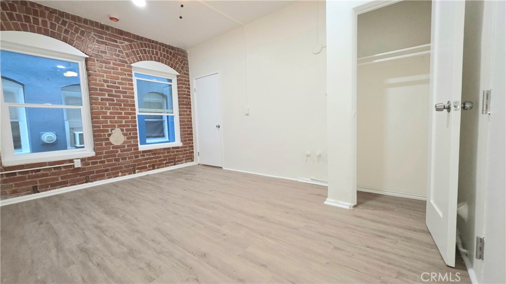 3408 Sunset Boulevard, Unit 107 Silver Lake, CA 90026 - Photo 10 of 12 an empty room with wooden floor and windows