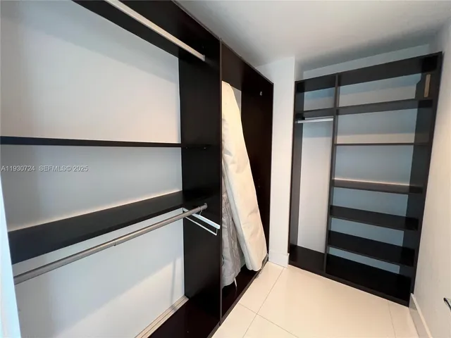 a bedroom with a bed chair and a large window