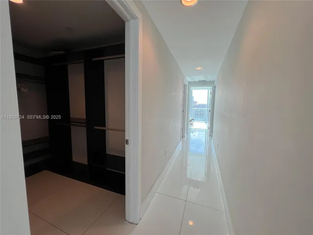 a bedroom with a bed and large windows