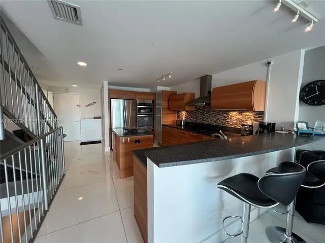 a kitchen with stainless steel appliances kitchen island granite countertop a sink and cabinets