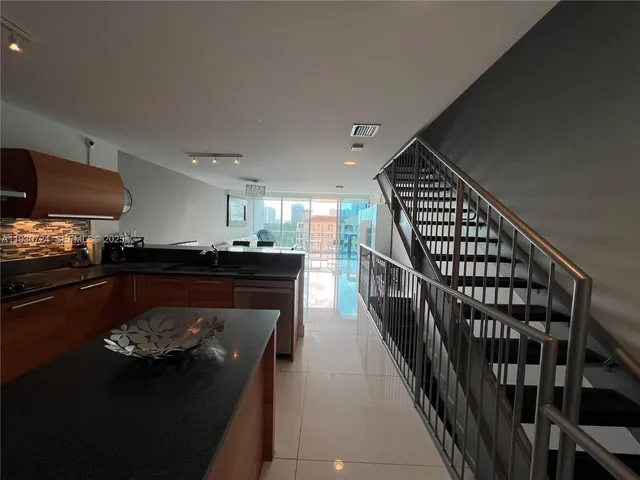 a kitchen with stainless steel appliances granite countertop a refrigerator a stove and a sink with wooden floor