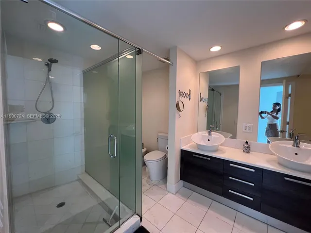 a bathroom with a double vanity sink toilet and shower
