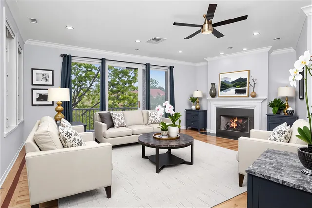 a living room with furniture a fireplace and a large window