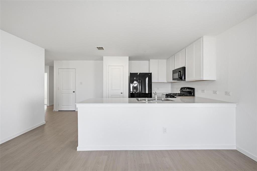 3707 Spring Run Drive Sherman, TX 75092 - Photo 5 of 18 a kitchen with stainless steel appliances a refrigerator sink stove and white cabinets