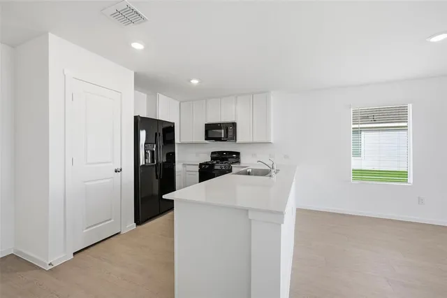 a kitchen with a refrigerator and a stove top oven