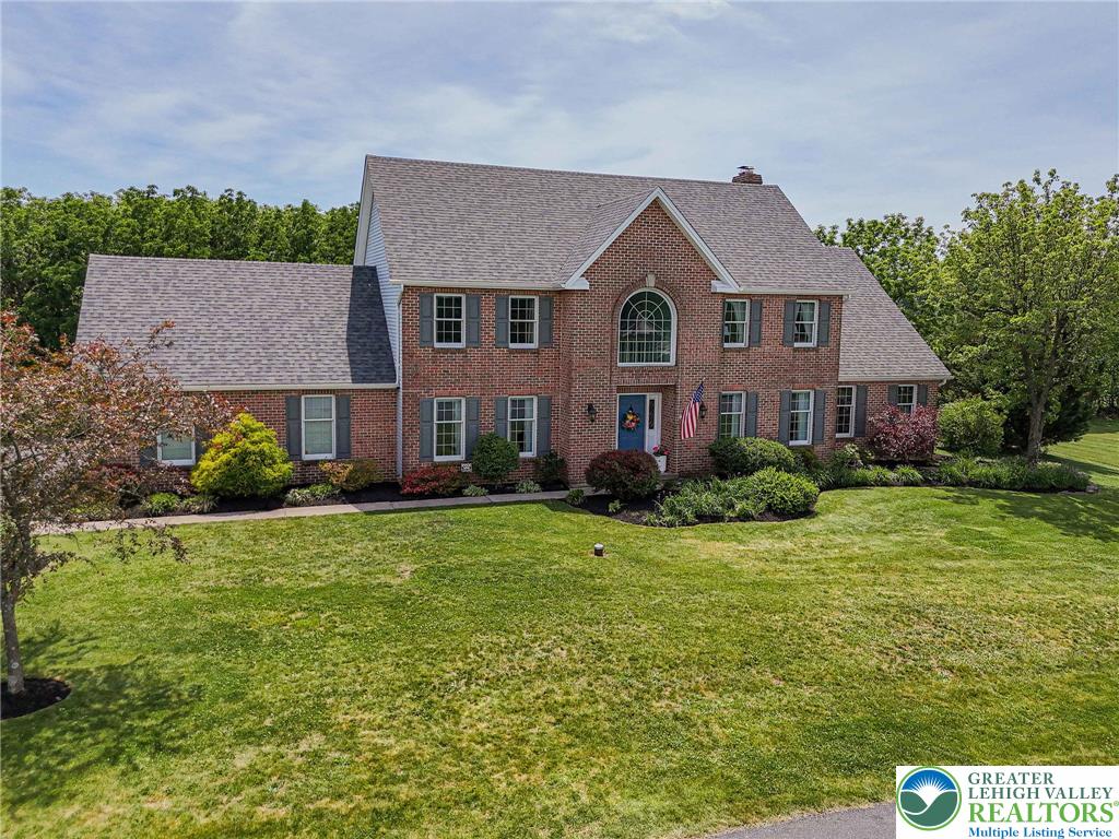 4542 Springfield Drive Coplay, PA 18037 - Photo 84 of 89 A classic brick exterior with a welcoming blue door and manicured landscaping.