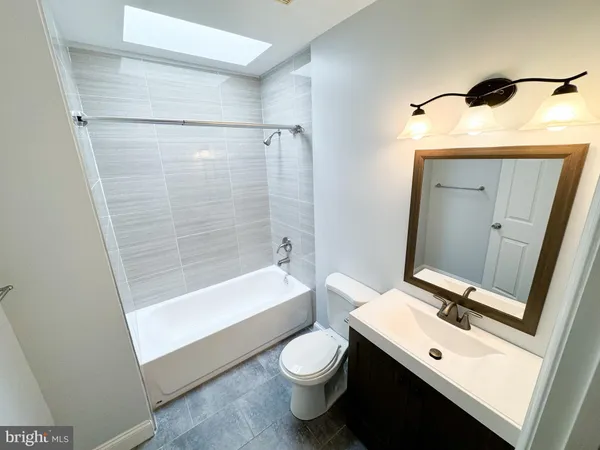 a bathroom with a sink a toilet and shower a mirror