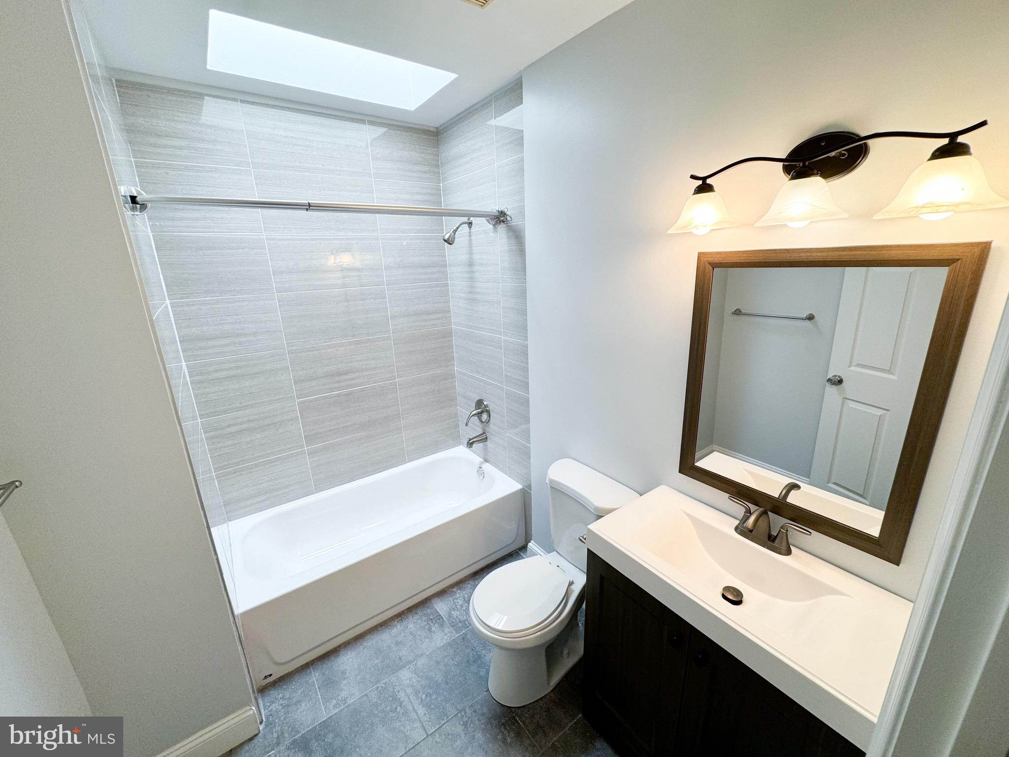 719 Euclid Street Northwest, Unit 4 Washington, DC 20001 - Photo 4 of 9 a bathroom with a sink a toilet and shower a mirror