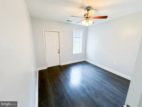 a view of a livingroom with wooden floor and a ceiling fan