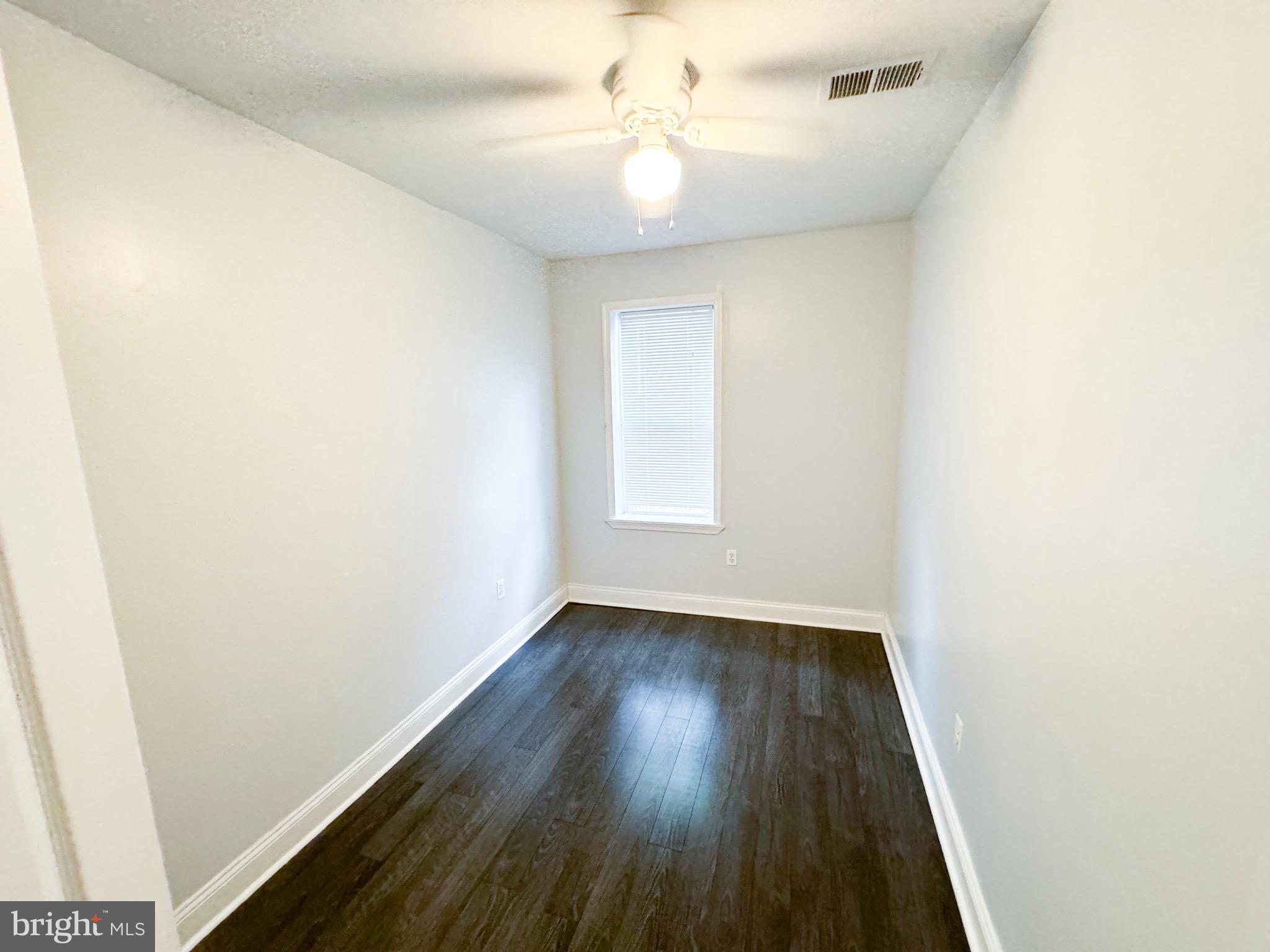 719 Euclid Street Northwest, Unit 4 Washington, DC 20001 - Photo 6 of 9 an empty room with wooden floor and fan