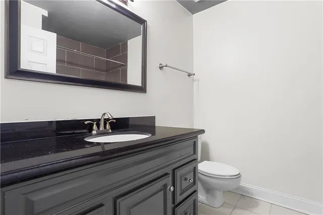 a bathroom with a granite countertop sink and a toilet