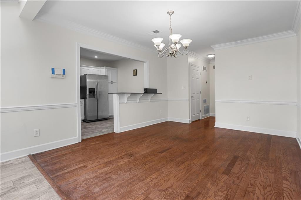 7500 Roswell Road, Unit 78 Atlanta, GA 30350 - Photo 15 of 22 a view of a kitchen with a refrigerator a ceiling fan and wooden floor