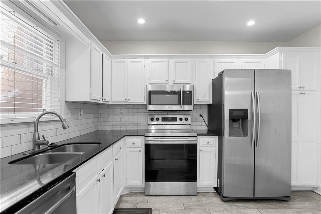 7500 Roswell Road, Unit 78 Atlanta, GA 30350 - Photo 17 of 22 a kitchen with stainless steel appliances granite countertop a refrigerator sink and stove