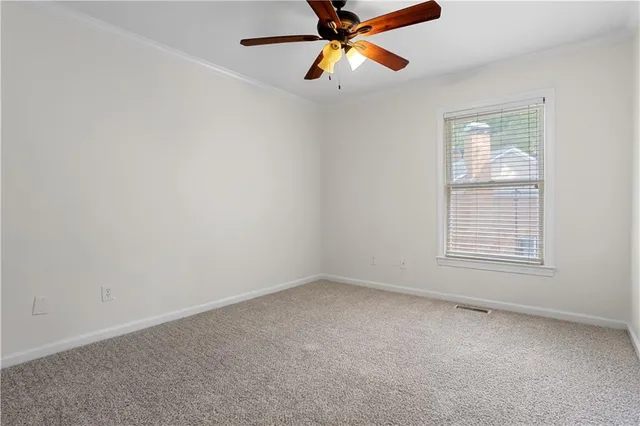an empty room with a window and a fan