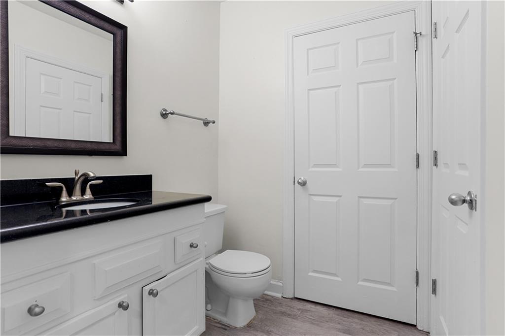 7500 Roswell Road, Unit 78 Atlanta, GA 30350 - Photo 19 of 22 a bathroom with a granite countertop sink toilet and mirror