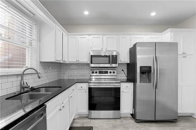 a kitchen with stainless steel appliances granite countertop a refrigerator and a stove top oven