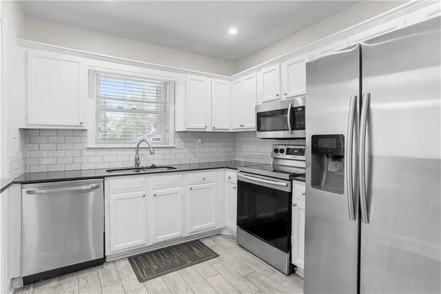 a bathroom with a granite countertop sink toilet and mirror