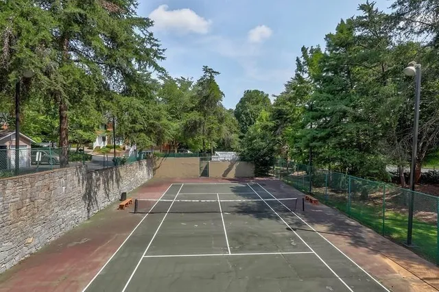 a view of a tennis court with trees in the background