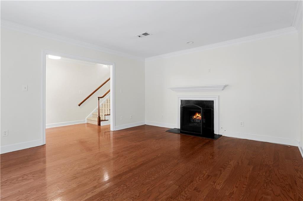 7500 Roswell Road, Unit 78 Atlanta, GA 30350 - Photo 8 of 22 a view of an empty room with wooden floor fireplace and a window