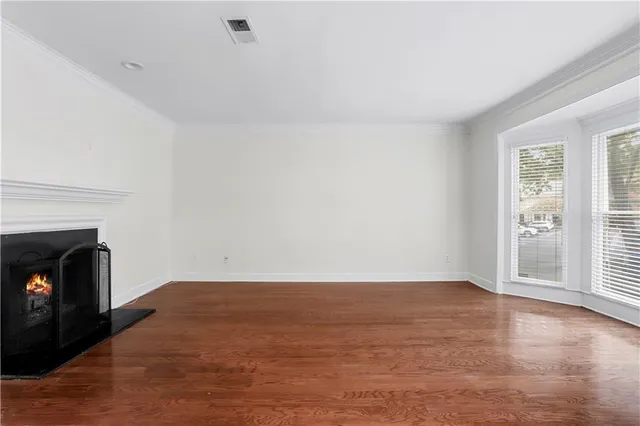 a view of empty room with wooden floor and fireplace