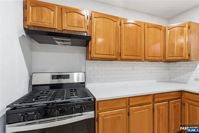 a kitchen with granite countertop cabinets and a stove top oven