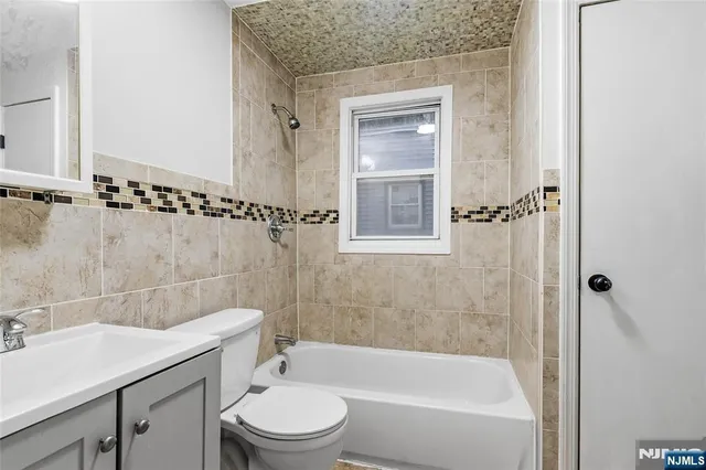 a bathroom with a granite countertop sink a toilet and shower